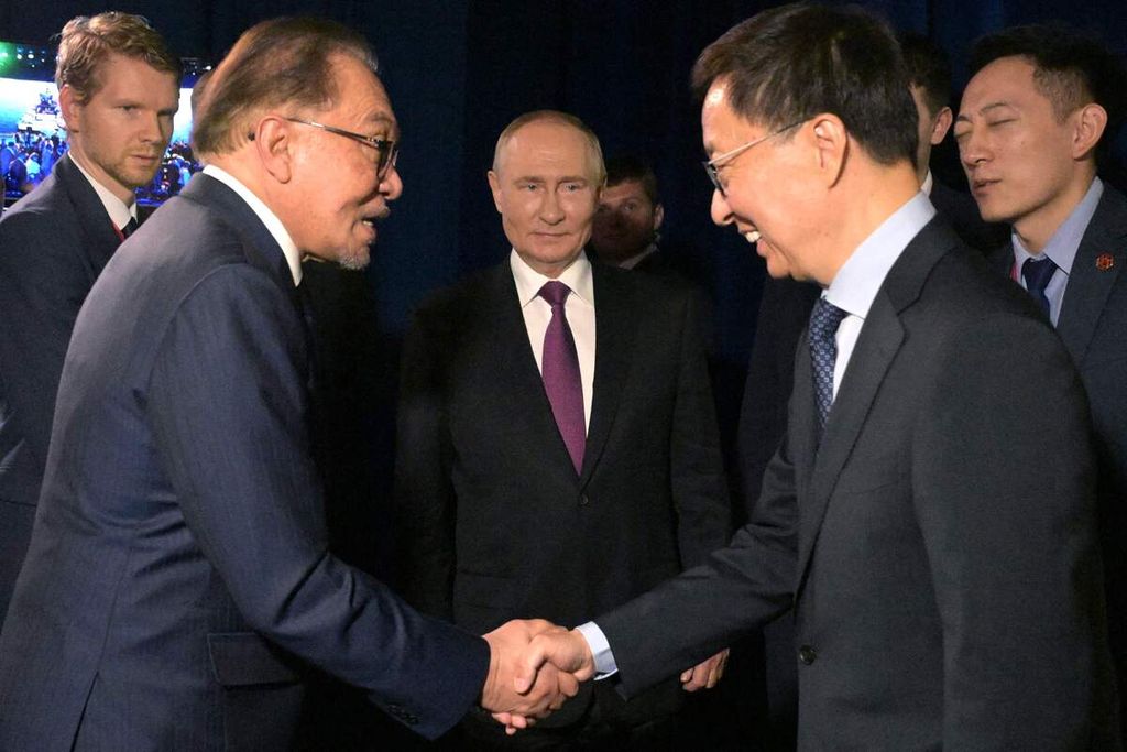 Presiden Rusia Vladimir Putin (tengah) menyaksikan PM Malaysia Anwar Ibrahim bersalaman dengan Wakil Presiden China Han Zeng di Vladivostok, Rusia, pada Kamis (5/9/2024).