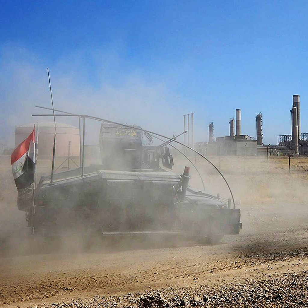 Kendaraan tempur pasukan Irak memasuki ladang minyak di Kirkuk, Irak, Senin (16/10). Pasukan Irak mengklaim menguasai bandara, basis militer, dan kilang minyak penting di Kirkuk dalam pertempuran dengan milisi Kurdi. 