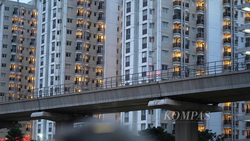 Lampu apartemen menyala di Cawang, Jakarta Timur, Senin (13/2/2023). Hunian berkonsep kawasan berorientasi transit (TOD) yang berdekatan dengan stasiun LRT kian diminati. 
