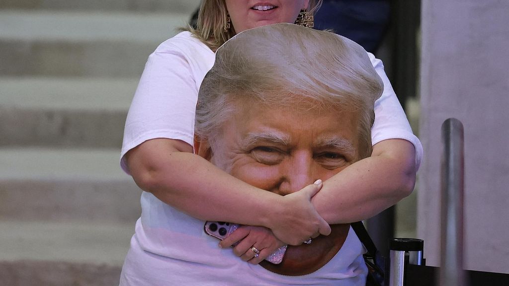 Seorang pendukung memegang foto calon presiden dari Partai Republik, mantan Presiden Donald Trump, selama rapat umum kampanye di Atrium Health Amphitheater pada 3 November 2024 di Macon, Georgia. 