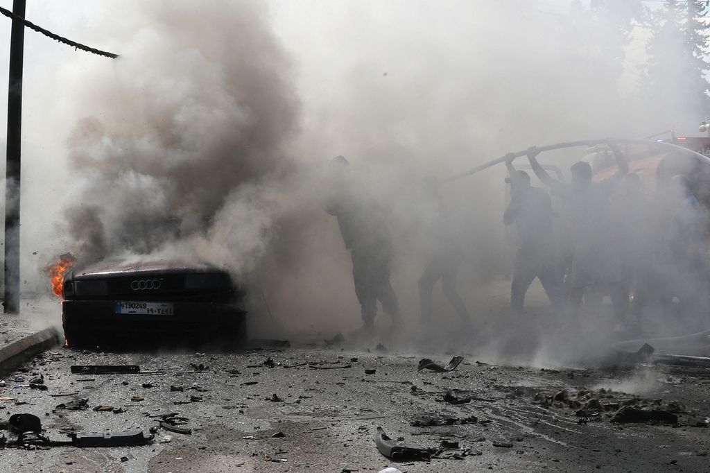 Petugas pemadam kebakaran Lebanon memadamkan api di sebuah mobil setelah serangan Israel di kota selatan Sidon, Rabu (21/8/2024). Serangan itu menewaskan seorang pejabat Fatah, Khalil Maqdah. 