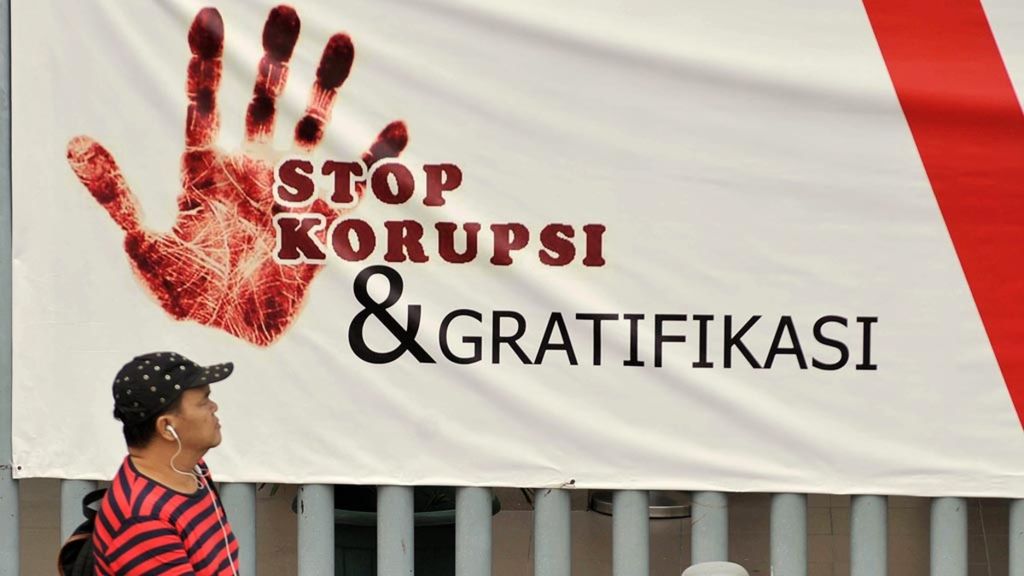 Warga melintas di depan spanduk bertuliskan Stop Korupsi dan Gratifikasi di Jalan MH Thamrin, Jakarta, Kamis (13/9/2018). Keberadaan spanduk tersebut diharapkan bisa membangun sikap dan kesadaran masyarakat untuk tidak korupsi dan menerima gratifikasi.