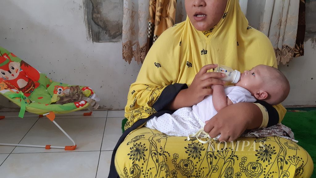 QR (21), ibu asal Medan, Sumatera Utara, sedang memberikan susu formula untuk bayinya yang berumur satu bulan di rumahnya, Rabu (31/8/2022). 