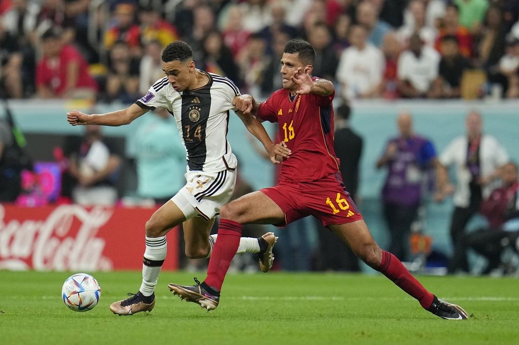 A player from the German national team, Jamal Musiala (left), competes for the ball with a player from the Spanish national team, Rodri, in the group stage match E of the Qatar 2022 World Cup at Al Bayt Stadium, Al Khor, on Sunday (27/11/2022). The match ended in a 1-1 draw.