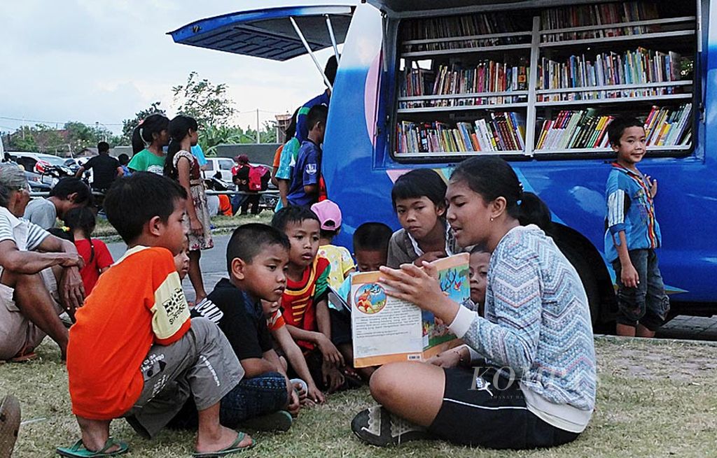Anak-anak pengungsi Gunung Agung  di Pos Komando Kebencanaan, GOR Swecapura,  Kabupaten Klungkung,  Bali, Jumat (29/9) sore,  asyik mendengarkan dongeng dari  sesama pengungsi.  Mereka mendapatkan pinjaman buku dongeng dan bacaan anak-anak dari Perpustakaan Keliling Provinsi Bali.   Bahan bacaan ini mampu menghibur, terutama anak-anak yang mulai jenuh di tempat pengungsian. GOR itu  menampung  sekitar 22.000 pengungsi.