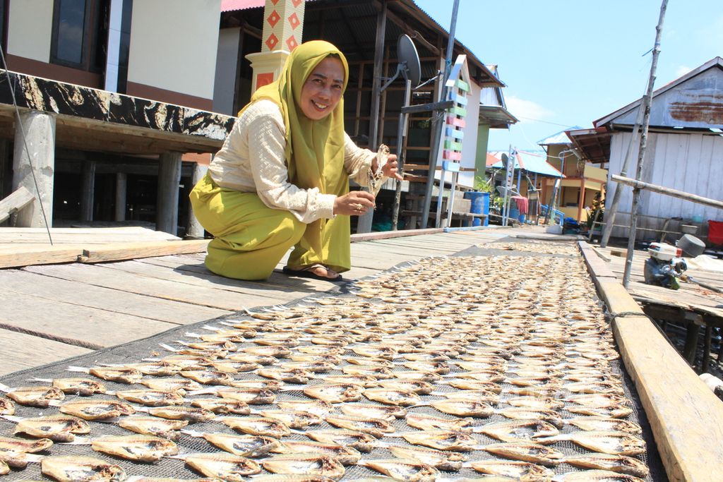 Rahmawati Dafrullah (51), Penjabat Kepala Desa Kaki Air, menunjukkan ikan kering yang dijemur di Desa Kaki Air, Kecamatan Teluk Kayeli, Kabupaten Buru, Maluku, Rabu (6/9/2023). 