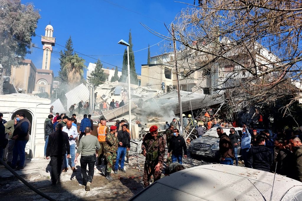 Warga dan tim penyelamat berkumpul di sebuah bangunan rumah tempat tinggal yang baru saja diserang oleh rudal yang diduga dilakukan Israel di kawasan Mazzeh, Damaskus, Suriah, Sabtu (20/1/2024). Serangan itu menewaskan dua perwira dan dua prajuirt Garda Revolusi Iran (IRGC) 