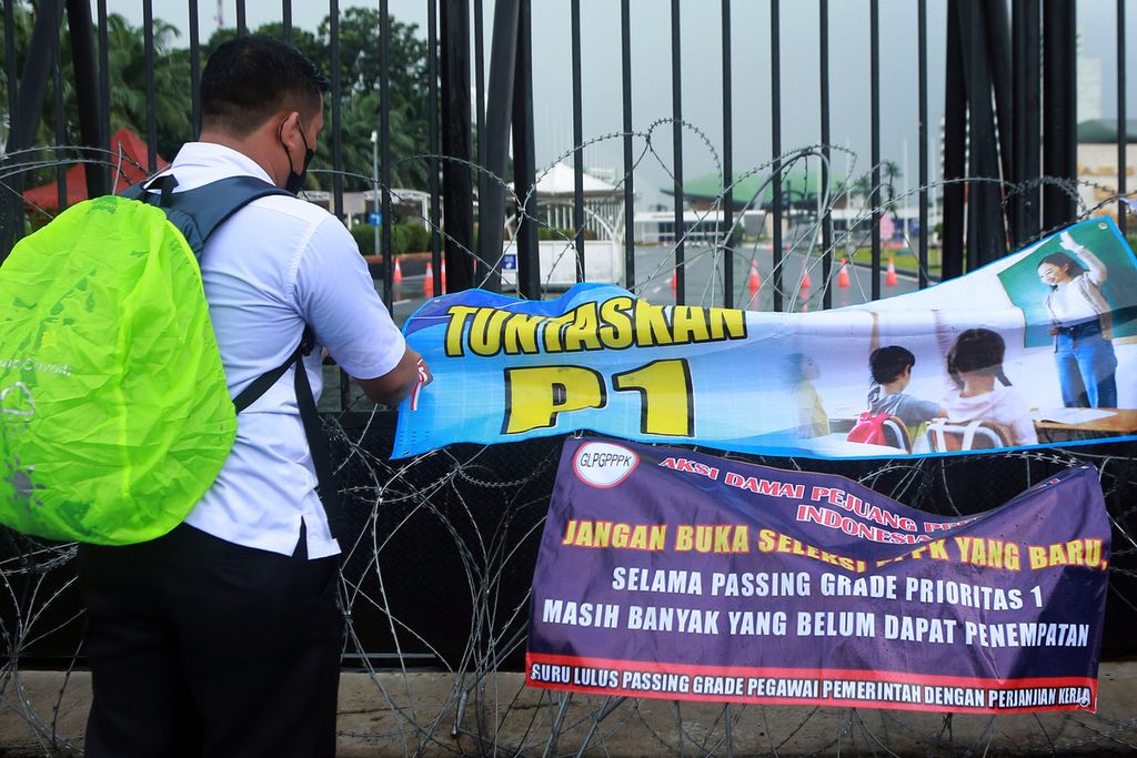 Seorang guru honorer memasang spanduk aksi saat demo menuntut hak guru honorer di depan Gedung DPR RI, Jakarta, Senin (7/11/2022). Mereka menuntut untuk ditempatkan dan diberikan surat keputusan pada guru pegawai pemerintah dengan perjanjian kerja (PPPK) prioritas 1 (P1), tunda pengadaan PPPK untuk prioritas 2, 3, dan umum, optimalisasi dan penempatan guru prioritas 1, anggaran penggajian PPPK sepenuhnya ditanggung oleh pusat. 