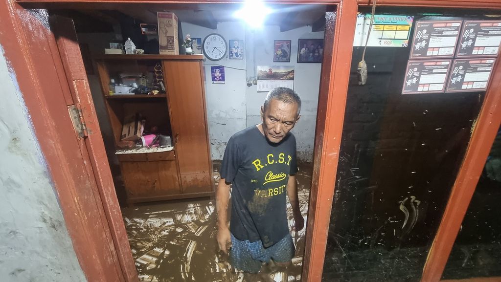 Salah satu warga mengamati suasana di luar rumahnya yang terkena endapan lumpur banjir luapan Sungai Cikapundung di RW 004 Kelurahan Braga, Kecamatan Sumur Bandung, Kota Bandung, Jawa Barat, Kamis (11/1/2024). 