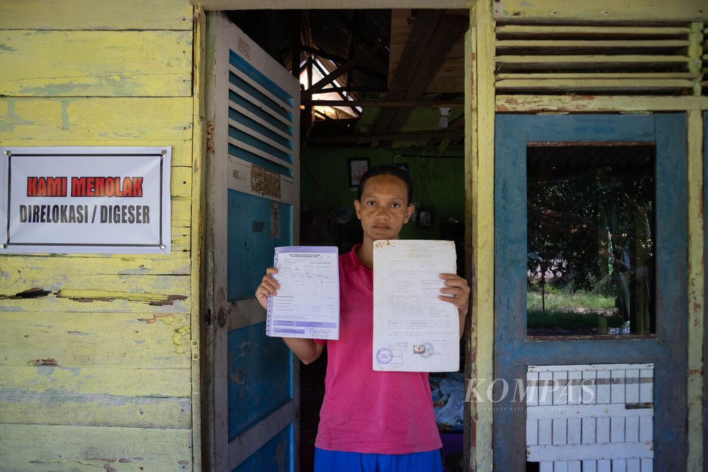 Kasinah (41) menunjukkan surat alas hak dan bukti pembayaran Pajak Bumi dan Bangunan rumahnya di Kampung Pasir Panjang, Pulau Rempang, Batam, Kepulauan Riau, Kamis (5/10/2023). 