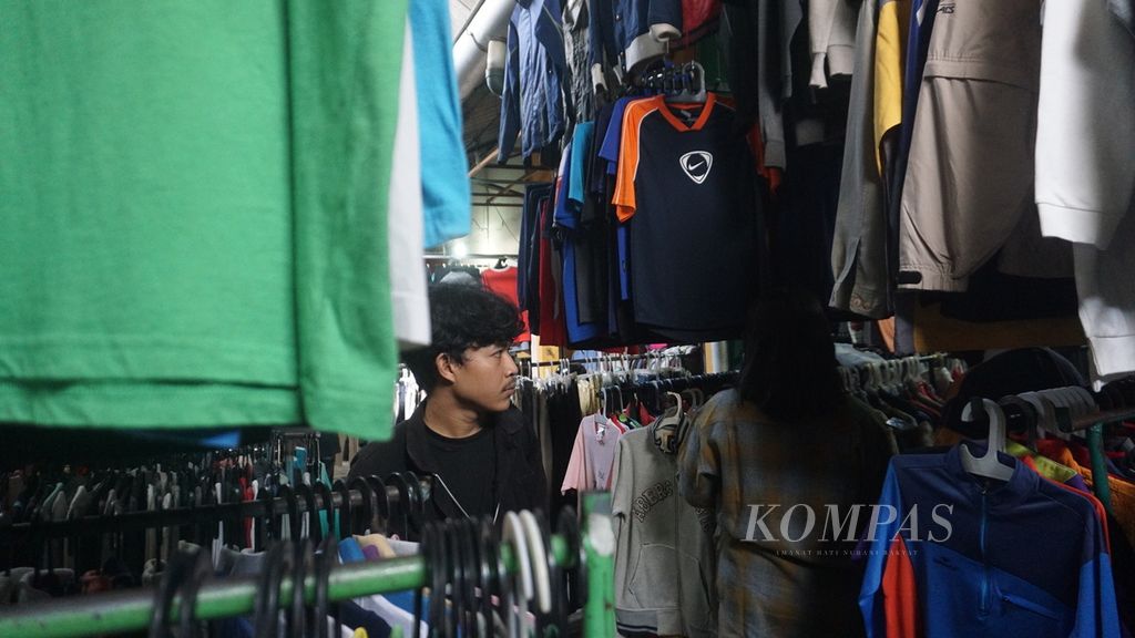Para pengunjung memilih-milih pakaian impor bekas di Pasar Notoharjo, Kota Surakarta, Selasa (7/6/2022). Belakangan, berburu pakaian bekas, yang disebut <i>thrifting,</i> menjadi tren di kalangan anak muda di Kota Surakarta.