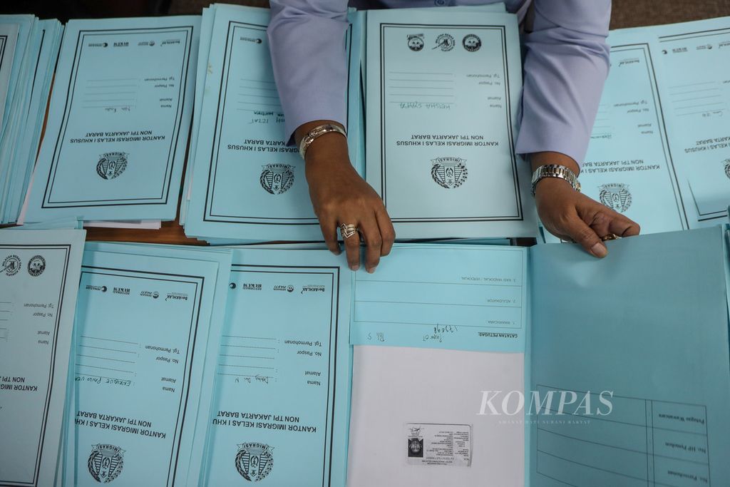 Petugas imigrasi memeriksa berkas para pemohon pembuat paspor di Kompas Institute, Gedung Unit II Kompas Gramedia, Palmerah, Jakarta, Selasa (18/7/2023). 