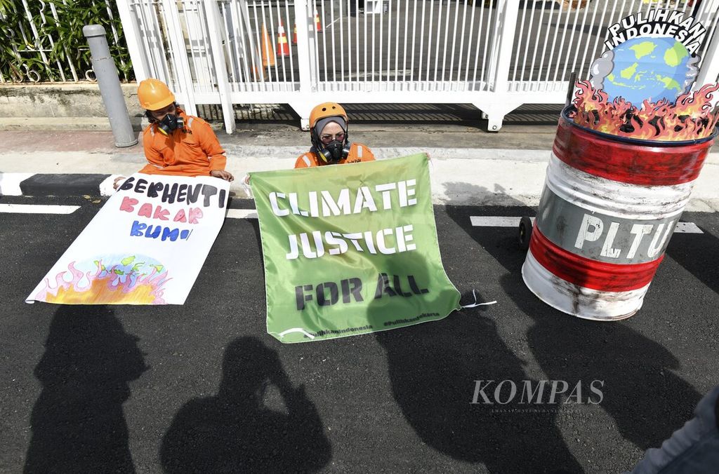 Aktivis lingkungan dari Wahana Lingkungan Hidup Indonesia (Walhi) Jakarta menggelar aksi di depan Gedung Kementerian Energi dan Sumber Daya Mineral di Jakarta, Jumat (11/12/2020). Aksi digelar menjelang lima tahun Perjanjian Paris pada 12 Desember 2020.