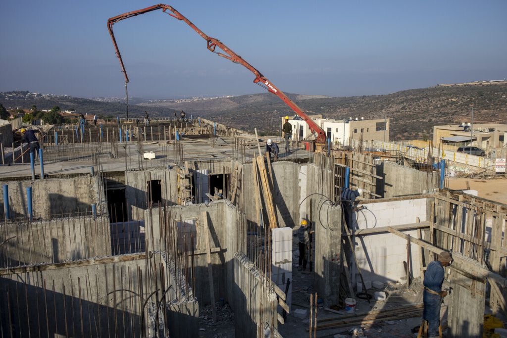 Sejumlah pekerja Palestina membangun perumahan baru di Bruchin, bagian dari permukiman warga Yahudi di dekat kota Nablus, Senin (25/1/2021). Israel akan melanjutkan pembangunan 1.355 perumahan bagi warga Yahudi di wilayah pendudukan. 