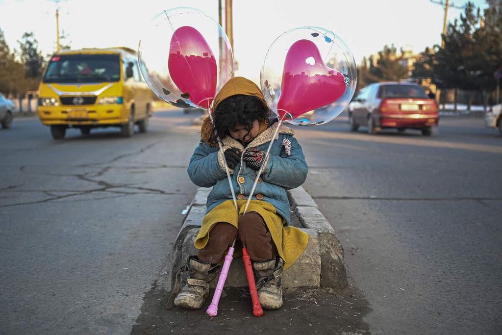 Seorang anak perempuan Afghanistan menjual balon di salah satu ruas jalan di Kabul, Afghanistan, 24 Januari 2022. 