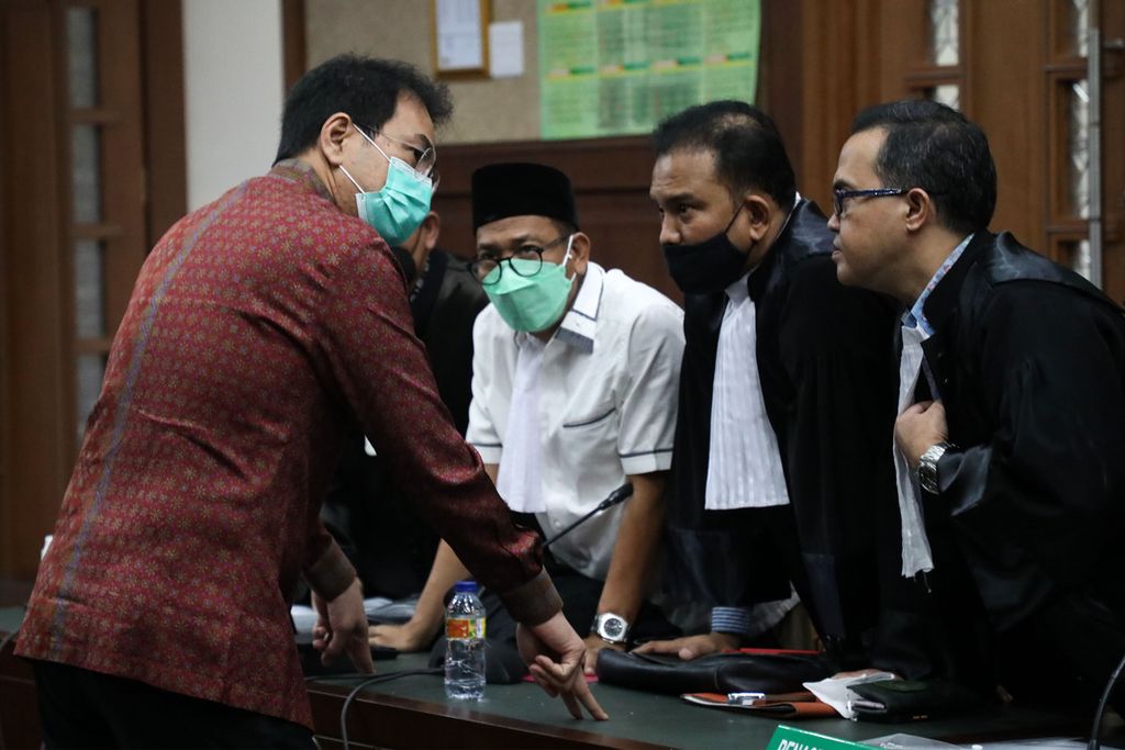 Bekas Wakil Ketua DPR, Azis Syamsuddin, berbincang dengan penasihat hukumnya seusai persidangan dengan agenda pembacaan dakwaan di Pengadilan Tindak Pidana Korupsi (Tipikor), Jakarta, Senin (6/12/2021). 