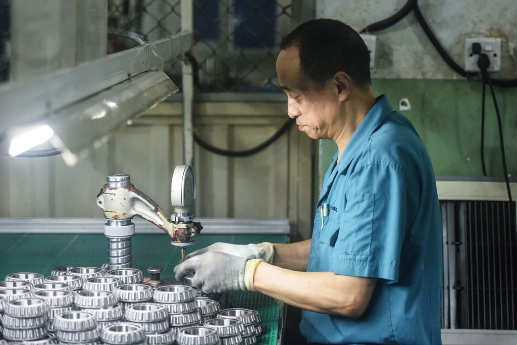 Seorang pria bekerja di pabrik komponen mobil, di Hangzhou, Provinsi Zhejiang, China, Senin (31/7/2023). Tak sedikit kaum muda di China yang memutuskan tinggal di rumah orangtua mereka dan bekerja mengurusi rumah. 