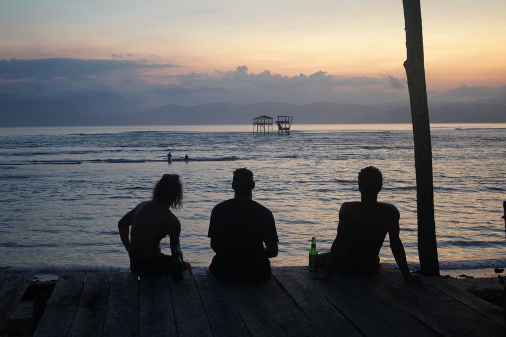 Sejumlah peselancar bersantai menikmati matahari terbenam di Pantai Lakey, Kecamatan Hu'u, Kabupaten Dompu, Nusa Tenggara Barat, Mei 2022 lalu.