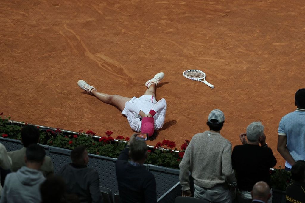 Iga Swiatek lay on the court after scoring the last point to secure a victory against Aryna Sabalenka in the WTA 1000 Madrid final on Saturday (4/5/2024).