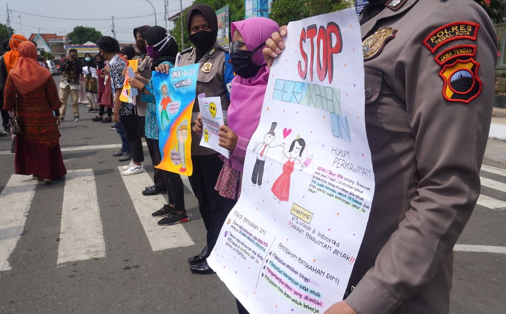 Anak-anak, polisi wanita Polres Tegal Kota, serta aktivis anti-kekerasan terhadap perempuan dan anak membawa poster berisi pesan-pesan perlawanan terhadap kekerasan kepada anak, Kamis (23/7/2020), di Kota Tegal, Jawa Tengah. Salah satu yang ingin disosialisasikan dalam kampanye tersebut adalah terkait penolakan terhadap pernikahan dini.