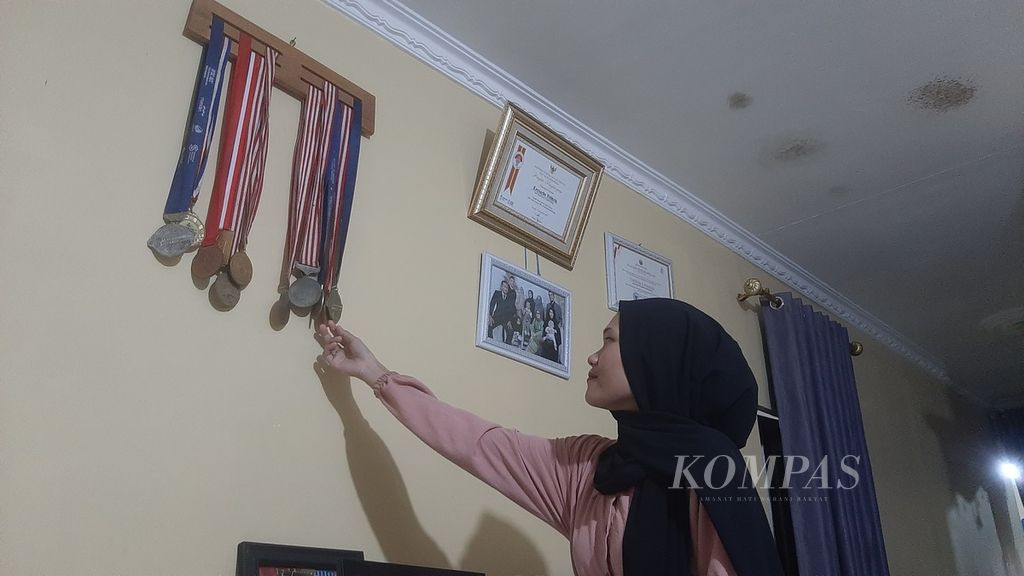 Violita Equada (25), adik perempuan Veddriq, peraih medali emas panjat tebing Olimpiade Paris, Perancis, 2024, sedang memperlihatkan medali yang pernah diraih sang Kakak, Kamis (8/8/2024).