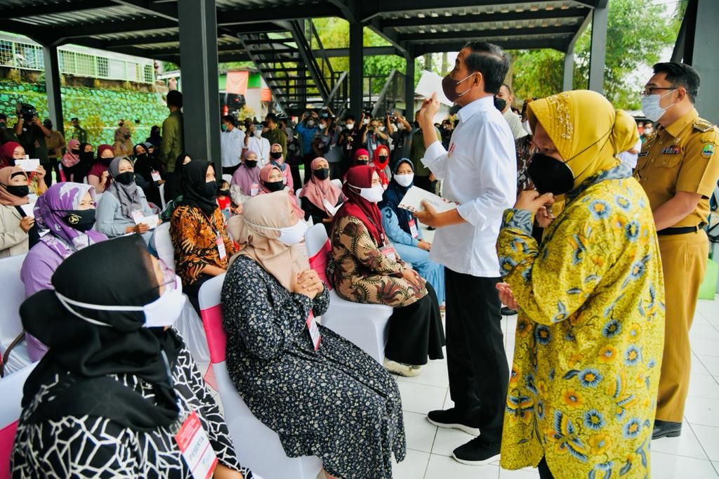 Presiden Joko Widodo membagikan bantuan modal kerja dan bantuan langsung tunai minyak goreng kepada penerima manfaat Program Keluarga Harapan dan pedagang di Pasar Cisarua, Kabupaten Bogor, Jawa Barat, Kamis (21/4/2022).