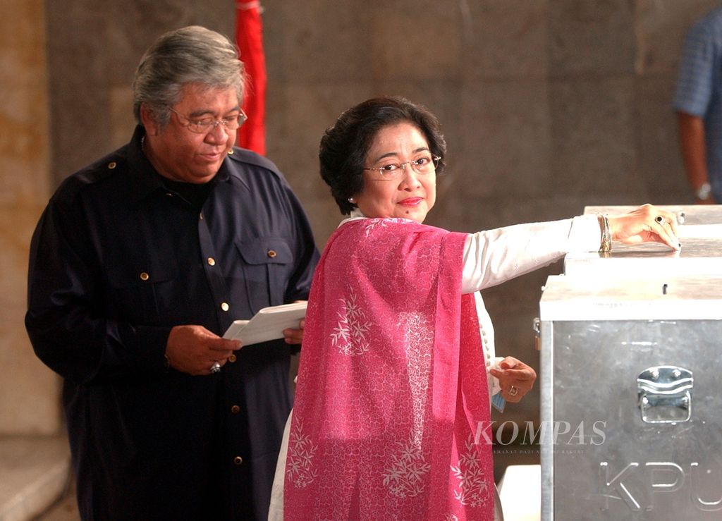 Presiden Megawati Soekarnoputri, didampingi suaminya, Taufik Kiemas, memasukkan surat suara untuk pemilihan anggota legislatif Pemilu 2004, Senin (5/4/2004), di TPS 001 Kelurahan Gondangdia, Jalan Teuku Umar, Jakarta. 