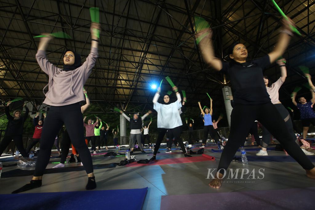 Puluhan orang mengikuti sesi olahraga <i>pound fit </i>di kompleks Gelora Bung Karno, Senayan, Jakarta, Kamis (12/5/2022). <i>Pound fit </i>menjadi olahraga baru yang sedang digemari masyarakat muda saat ini yang memadukan gerakan, seperti menabuh drum dengan alunan musik energik, yang bermanfaat untuk menurunkan berat badan.  