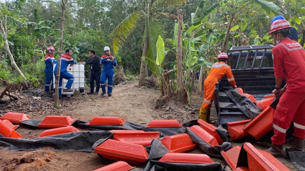 Petugas lapangan sedang menyiapkan <i>slickbar oil boom</i> untuk menahan agar air sungai yang terkena rembesan BBM tidak mengalir, di Jeruklegi, Cilacap, Jawa Tengah, Kamis (4/8/2022).