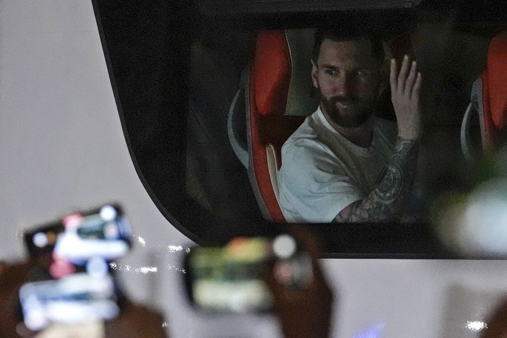 Bintang sepak bola asal Argentina, Lionel Messi, melambaikan tangan kepada penggemarnya saat kembali ke hotel seusai latihan di Beijing, China, Senin (12/6/2023). Argentina akan melawan Australia dalam laga persahabatan di Beijing, Kamis (15/6/2023). 
