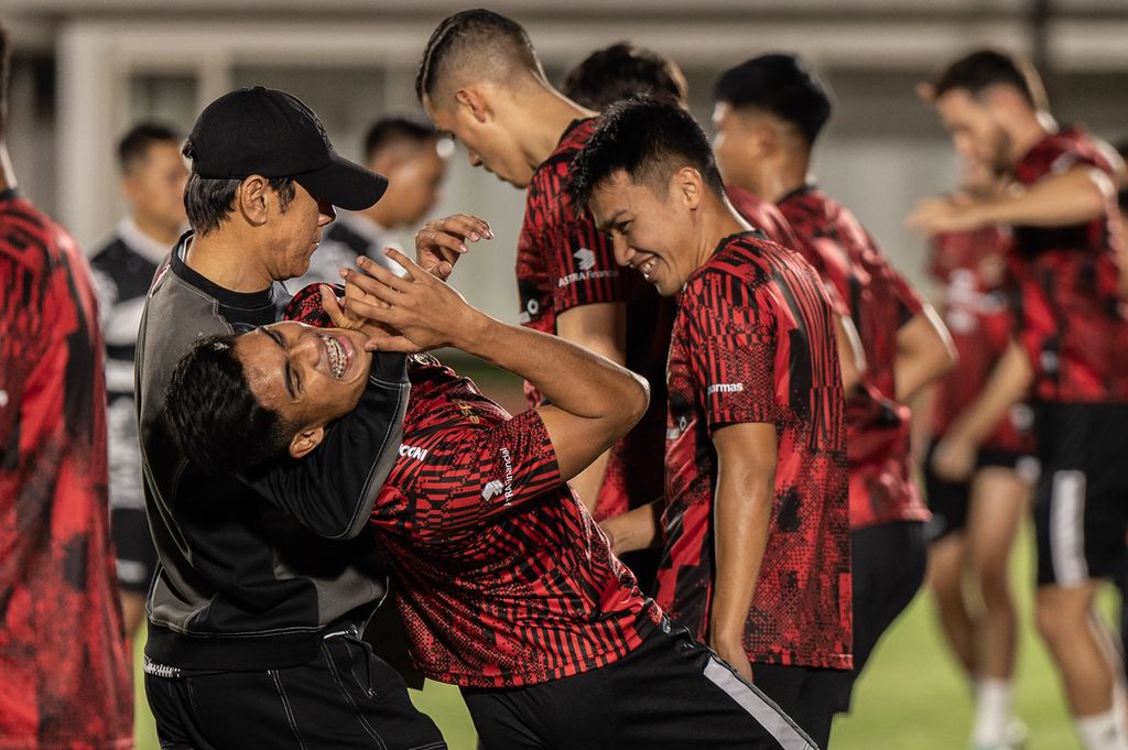 Pelatih Indonesia Shin Tae-yong (kiri) bercanda dengan para pemain saat sesi latihan di Stadion Madya, Senayan, Jakarta, Senin (18/3/2024). 
