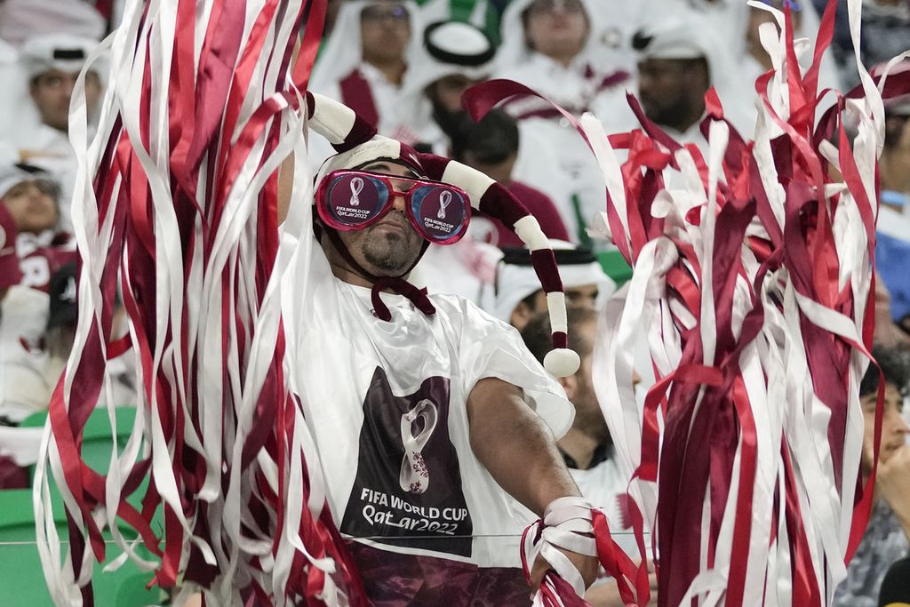 Seorang penggemar Qatar bersorak saat pertandingan sepak bola Grup A Piala Dunia antara Qatar dan Senegal, di Stadion Al Thumama di Doha, Qatar, Jumat (25/11/2022). Qatar takluk, 1-3, dan tersingkir. 