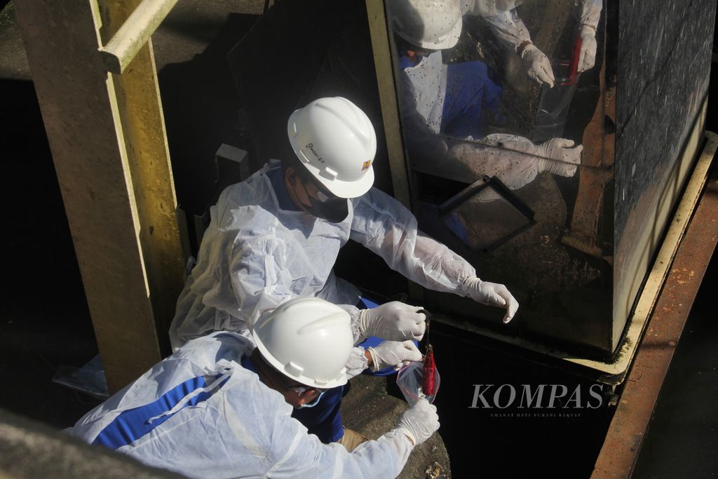 Petugas mengambil alat <i>passive sampler</i> yang berisi sampel air limbah di kompleks Instalasi Pengolahan Air Limbah (IPAL) Sewon, Kabupaten Bantul, Daerah Istimewa Yogyakarta, Rabu (6/4/2022). 