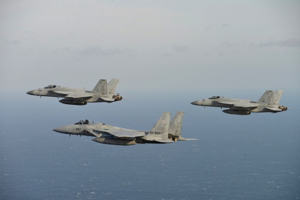 Dua jet tempur AS, F/A-18 (kiri), dan jet tempur F-15 milik Angkatan Udara Bela Diri Jepang terbang bersama dalam latihan militer di lokasi yang tidak disebutkan, dalam foto yang dirilis Pasukan Bela Diri Udara Jepang, 10 November 2017.