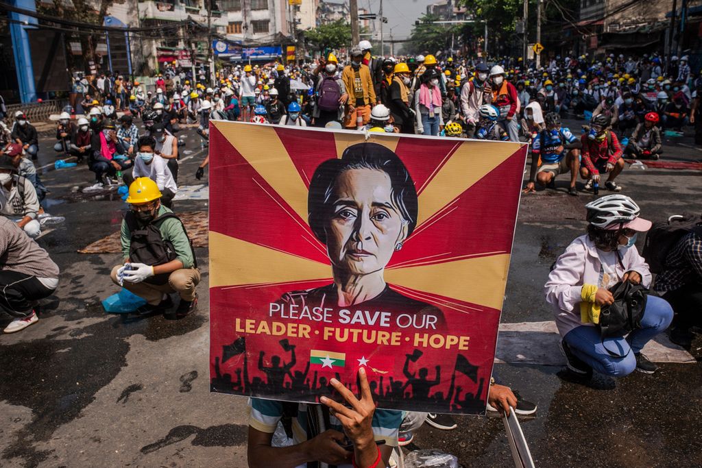 Pengunjuk rasa membawa poster bergambar Pemimpin Myanmar Aung San Suu Kyi yang dikudeta oleh junta militer dalam unjuk rasa di Yangon, Myanmar, 2 Maret 2021. (Photo by AFP)
