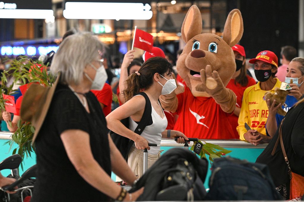 Beberapa penumpang yang baru turun dari pesawat disambut seekor maskot kanguru, hewan asli Australia, ketika tiba di Bandara Internasional Sydney, Australia, Senin (21/2/2022). Setelah dua tahun menutup perbatasannya, Pemerintah Australia secara resmi membuka kembali pintu kedatangan bagi warga asing ke negara tersebut. 