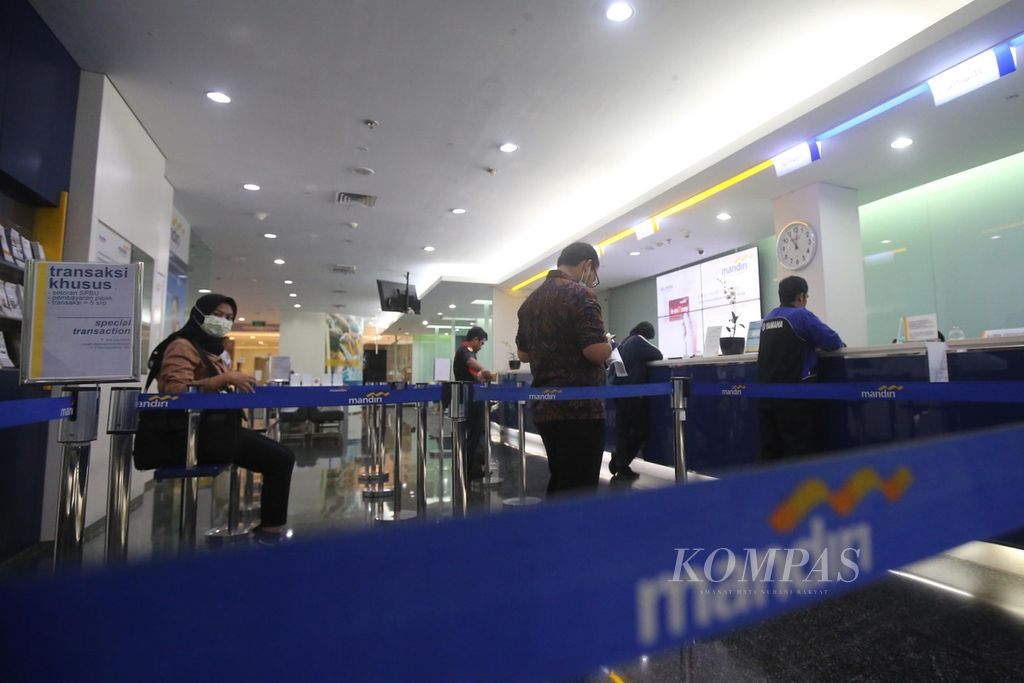 Nasabah antre untuk melakukan aktivitas perbankan di kantor cabang Plaza Mandiri, Jalan Gatot Subroto, Jakarta, Selasa (17/3/2020). Aktivitas perbankan masih berjalan normal walaupun ada imbauan bekerja dari rumah terkait pandemi virus korona.