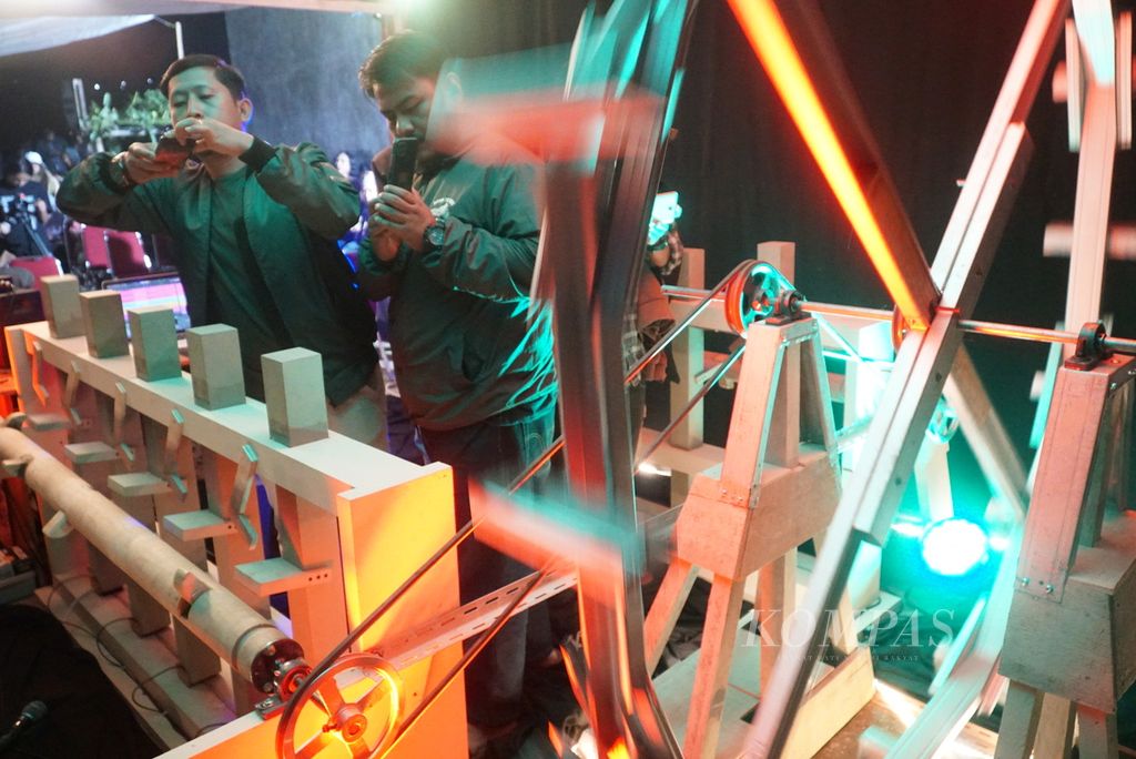 Penonton menyaksikan instalasi replika kincir air yang digunakan komposer Rani Jambak dalam menampilkan karya musik Kincia Aia: Malenong (M)ASO di Rumah Gagas, Nagari Lasi, Kecamatan Candung, Agam, Sumatera Barat, Jumat (22/7/2022) malam. Karya musik eksperimental itu terinspirasi dari teknologi <i>kincia aia</i> atau kincir air Minangkabau yang setidaknya sudah ada sejak 204 tahun silam.