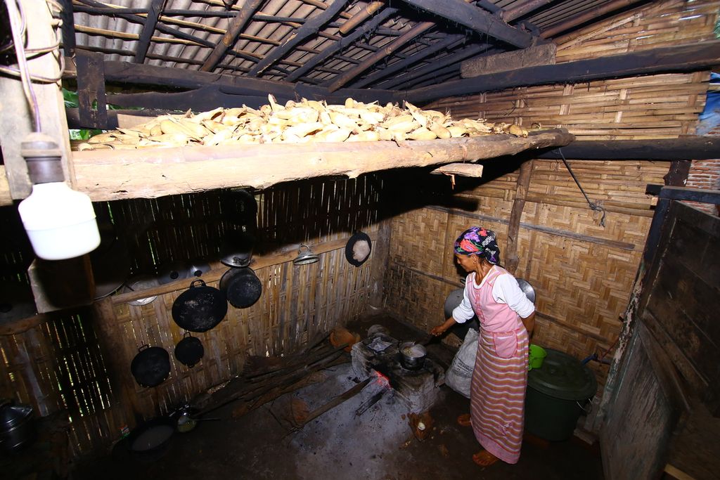 Muasnah (50) memasak di dapur yang dilengkapi lumbung jagung di bagian atasnya di rumahnya yang terletak di Lingkungan Papring, Kecamatan Kalipuro, Banyuwangi, Kamis (7/5/2020). Lumbung jagung ditempatkan di atas perapian agar jagung kering dan tidak berjamur.