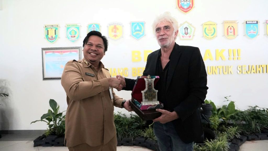 Sekretaris Daerah Provinsi Kalimantan Selatan Roy Rizali Anwar (kiri) memberikan kenang-kenangan kepada Sekretaris Jenderal UNESCO Global Geopark Network Guy Martini (kanan) di Banjarbaru, Selasa (25/10/2022).