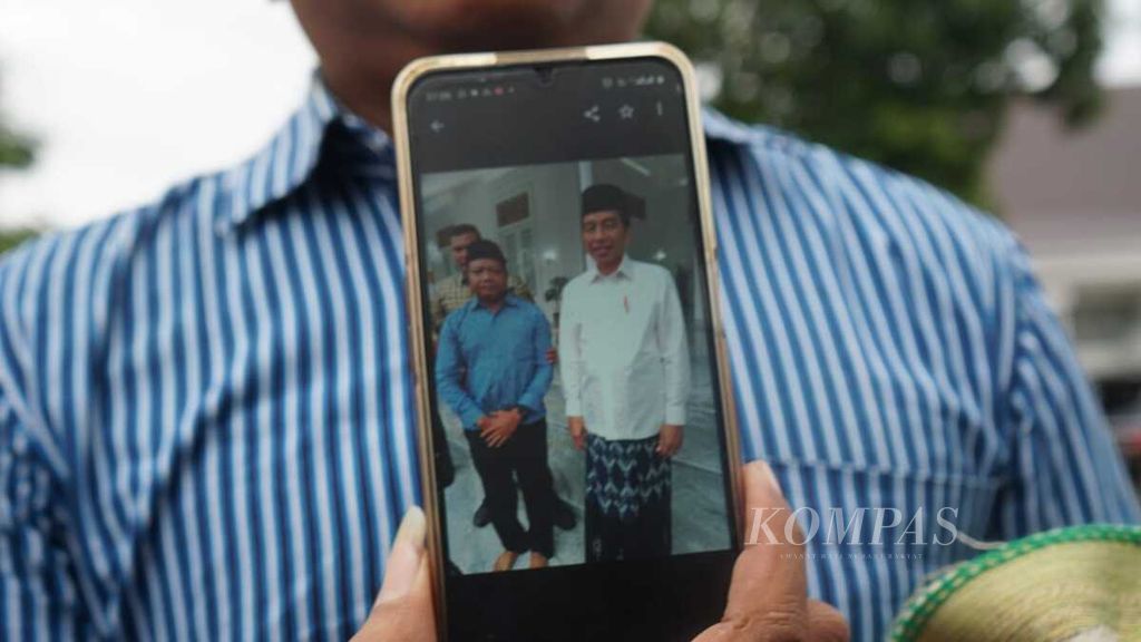 Salah seorang warga menunjukkan hasil fotonya bersama Presiden Joko Widodo setelah mengikuti shalat Idul Adha di Istana Kepresidenan Yogyakarta, Daerah Istimewa Yogyakarta, Kamis (29/6/2023).