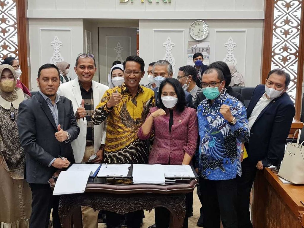Menteri Pemberdayaan Perempuan dan Perlindungan Anak I Gusti Ayu Bintang Darmawati Puspayoga (kedua dari kanan) bersama Ketua Badan Legislasi (Baleg) DPR Supratman Andi Agtas (tengah) berfoto bersama seusai menandatangani hasil rapat pleno pengambilan keputusan tingkat satu atas hasil pembahasan Rancangan Undang-Undang Tindak Pidana Kekerasan Seksual (RUU TPKS) dengan Badan Legislasi DPR di Kompleks Parlemen, Senayan, Jakarta, Rabu (6/4/2022).