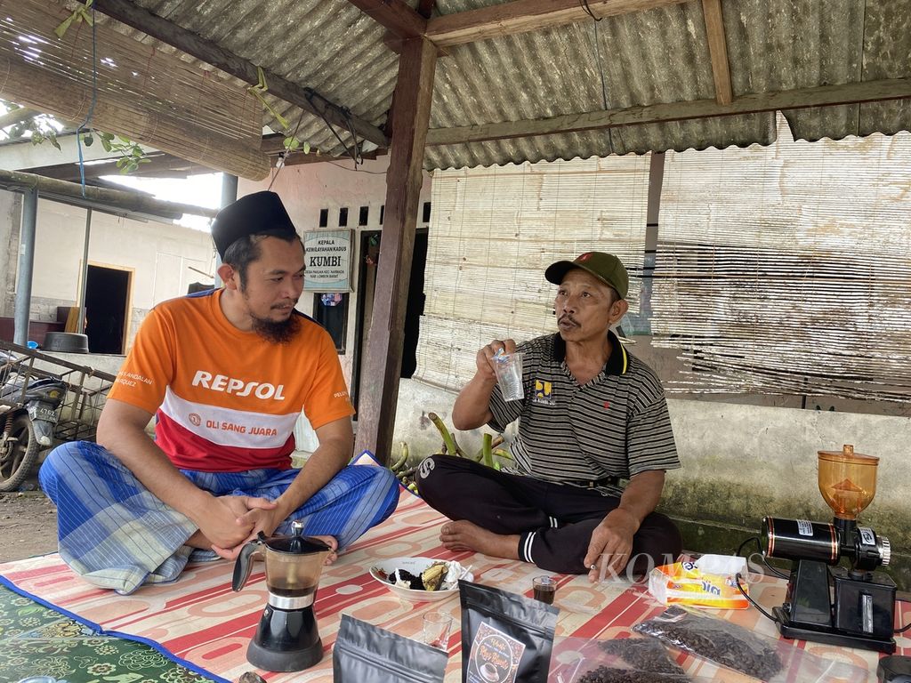 Saringgih (kiri), Kepala Dusun Kumbi, Desa Pakuan, Kecamatan Narmada, Lombok Barat, Nusa Tenggara Barat, berkumpul bersama warga sambil menikmati kopi, Kamis (5/5/2022).