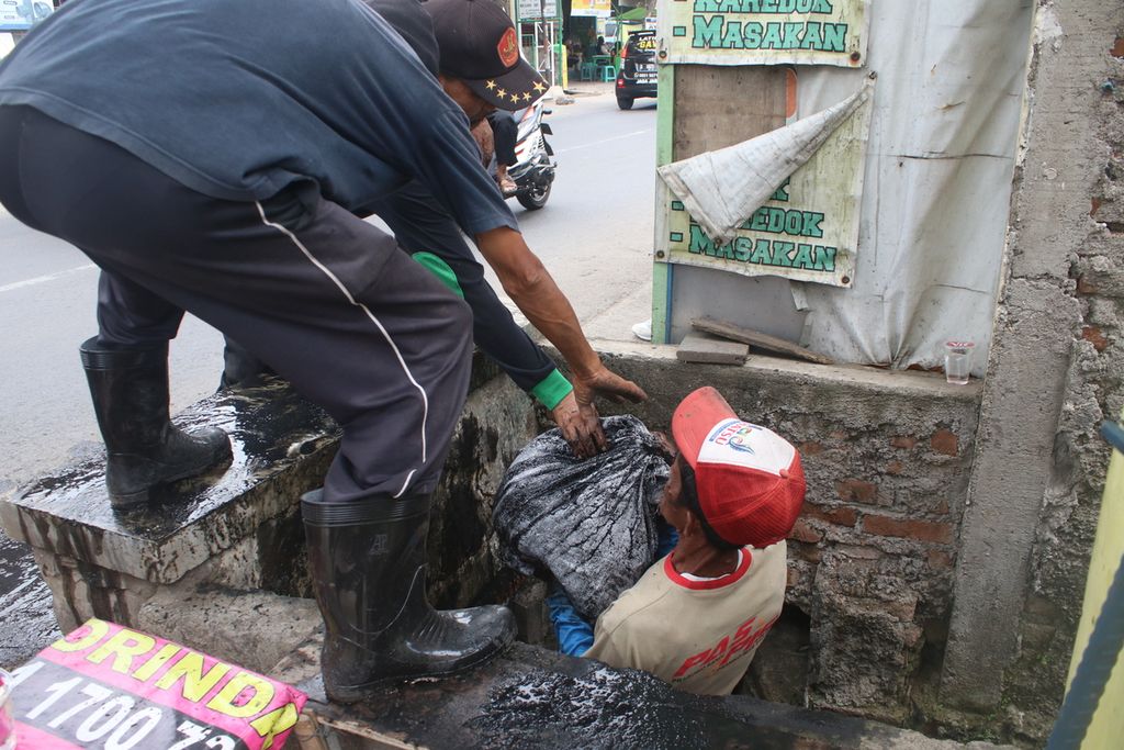Warga peserta program padat karya mengangkut sampah dari selokan di RW 003, Kelurahan Mekarjaya, Kecamatan Rancasari, Kota Bandung, Jawa Barat, Kamis (22/9/2022). Mereka membersihkan saluran sebagai antisipasi musim hujan.