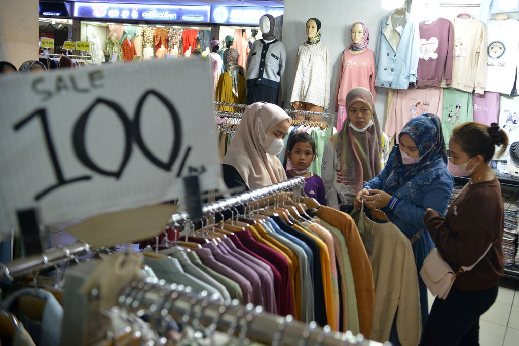 Sejumlah warga memilih pakaian yang dijual di salah satu toko di Pasar Tanah Abang, Jakarta Pusat, Senin (2/1/2022). 