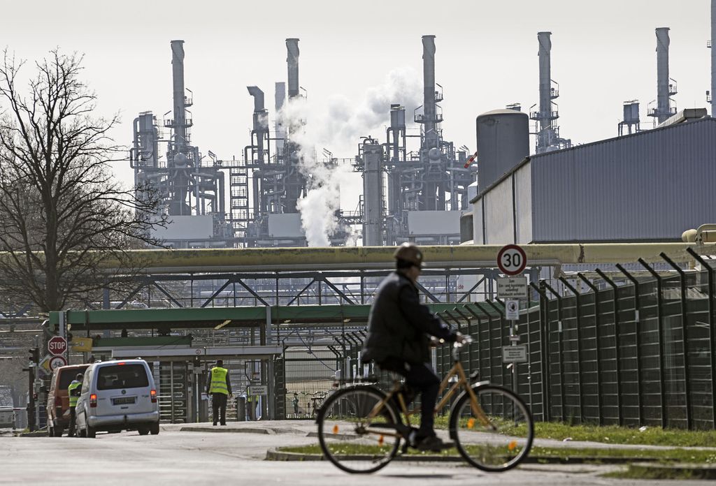 Seorang pekerja mengendarai sepeda ke kompleks pengolahan minyak BP, Ruhr Oil, di Gelsenkirchen, Jerman, Senin (28/3/2022). 