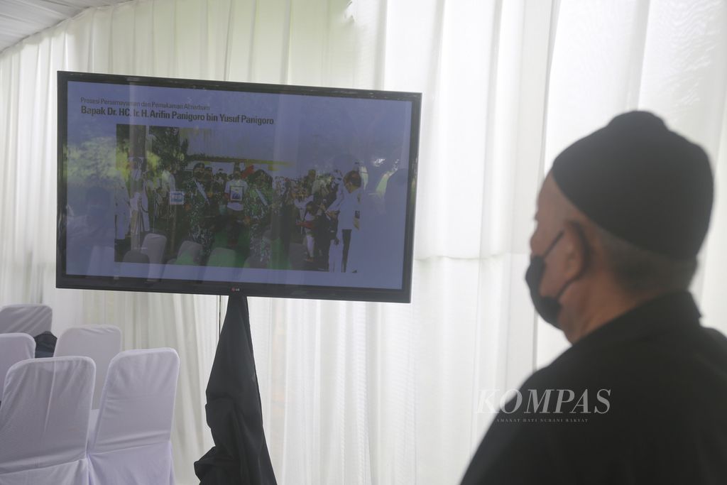 Warga menyaksikan pemakaman pendiri Medco Group, Arifin Panigoro, melalui layar TV yang disediakan panitia.