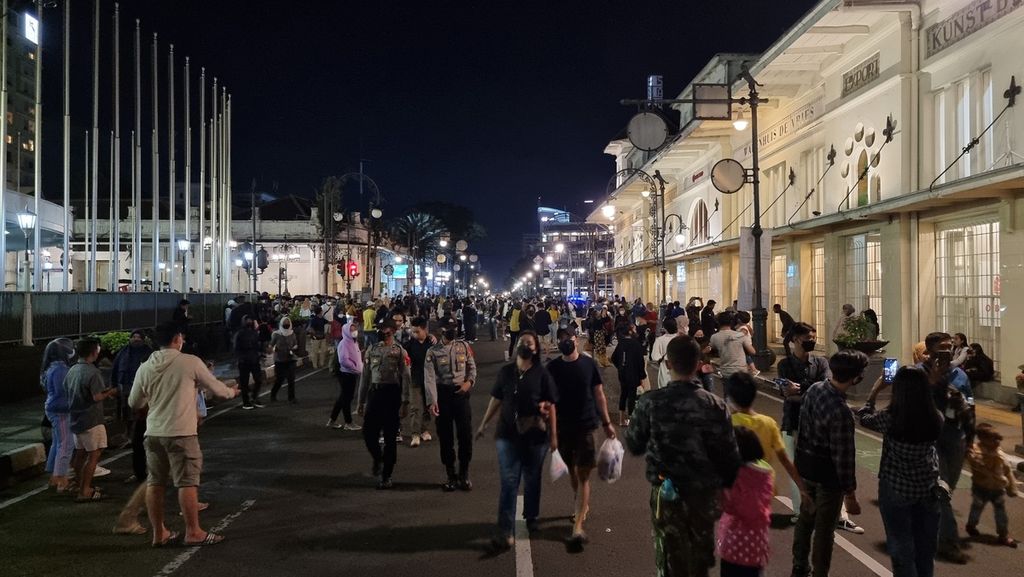 Para pengunjung memadati ruas Jalan Asia Afrika saat malam pergantian tahun baru 2022, Jumat (31/12/2021) malam. Jalan di pusat Kota Bandung ini sempat ditutup, tetapi dibuka kembali menjelang detik-detik pergantian tahun baru.