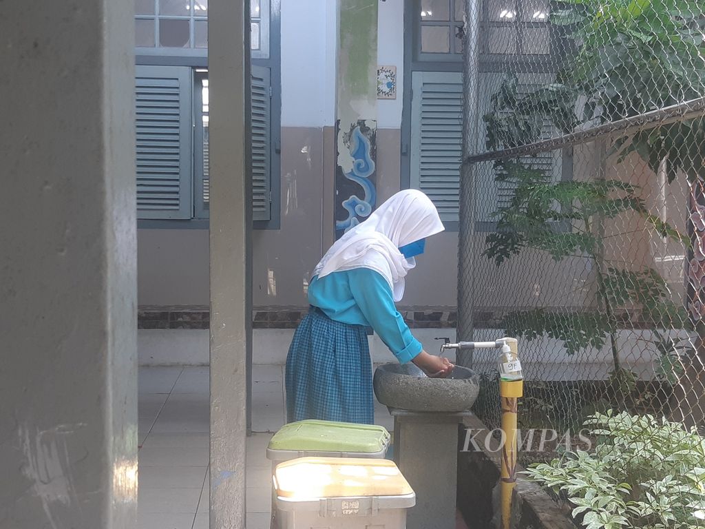 Siswa mencuci tangan saat memasuki SMPN 1 Kota Cirebon, Jawa Barat, Rabu (3/11/2021). Memasuki PPKM level 4, Pemkot Cirebon mulai Rabu (23/2/2022) menjalankan pembelajaran jarak jauh.