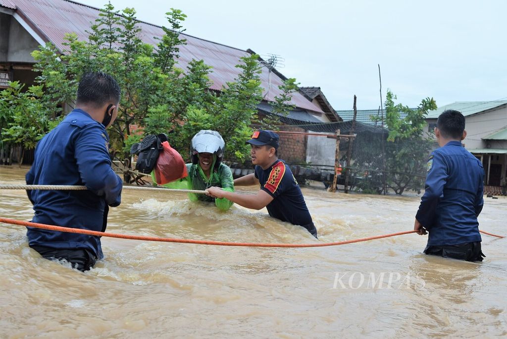 Petugas dari Dinas Pemadam Kebakaran dan Penyelamatan Kota Jambi membantu evakuasi korban banjir di Perumahan Kembar Lestari II, Kota Jambi, Kamis (31/12/2020).